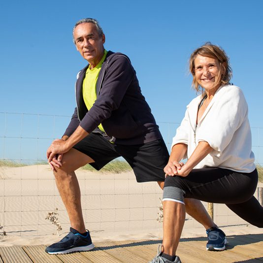Hombre y mujer adultos mayores disfrutando practicar ejercicio.